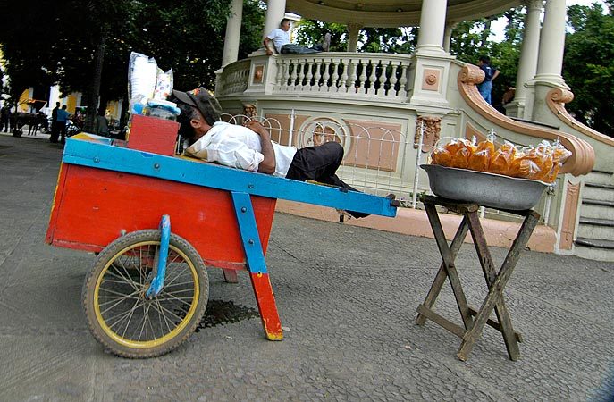 A Nicaraguan Vendor taking a mid-day siesta in the central square in Granada.