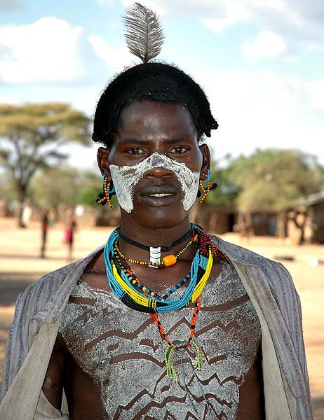 Hammer man in Turmi - notice the mix of new and old - feather and beads vs. metal watchband and spring