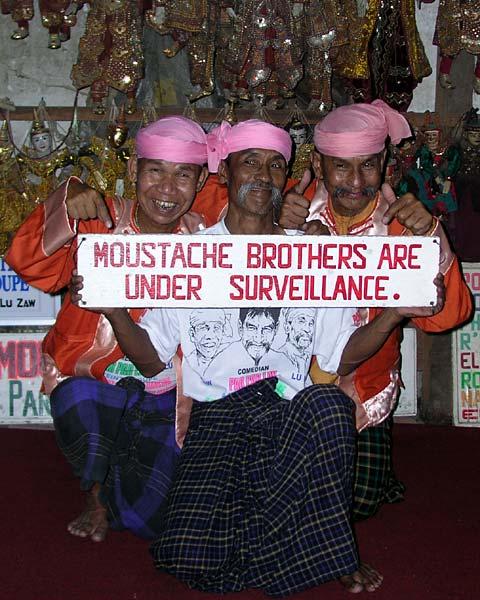 They are comedians, but this isn't a joke. Two of the three of them spent 7 years in jail for telling a joke. It wasn't even an anti-government joke - just pro-opposition. And, as the sign says they are still under surveillance.