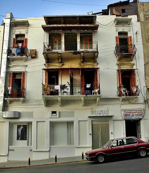 Mediterranean architecture with everyone relaxing on their porches to enjoy the ocean breeze on a very hot day.
