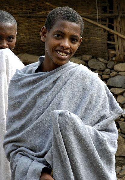 A traditionally dressed boy in Gonder.  The material is both used as clothing and as a blanket.