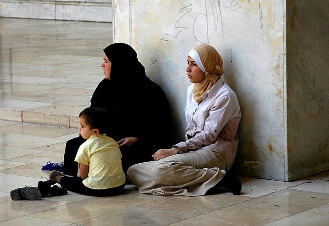 Women relaxing in the shade in the Umayyad Mosque on a hot day in Damascus.
