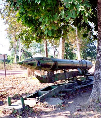 A Vietnam war anti-aircraft missile still hidden under a tree where it was left at the end of the war.